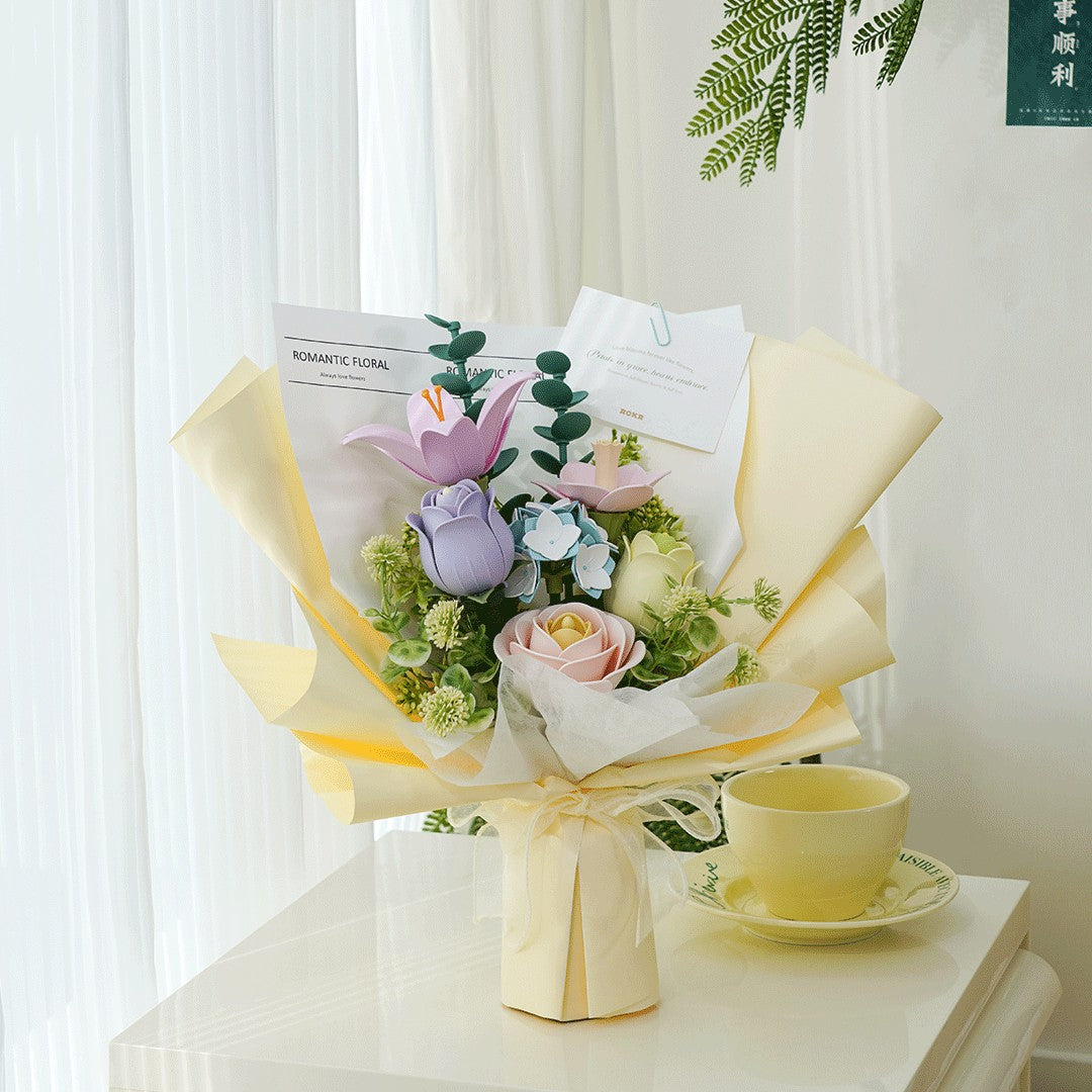 Bouquet of flowers wrapped in yellow paper on a table with a cup and saucer.