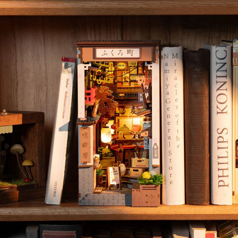 Miniature model of a town scene behind books on a shelf