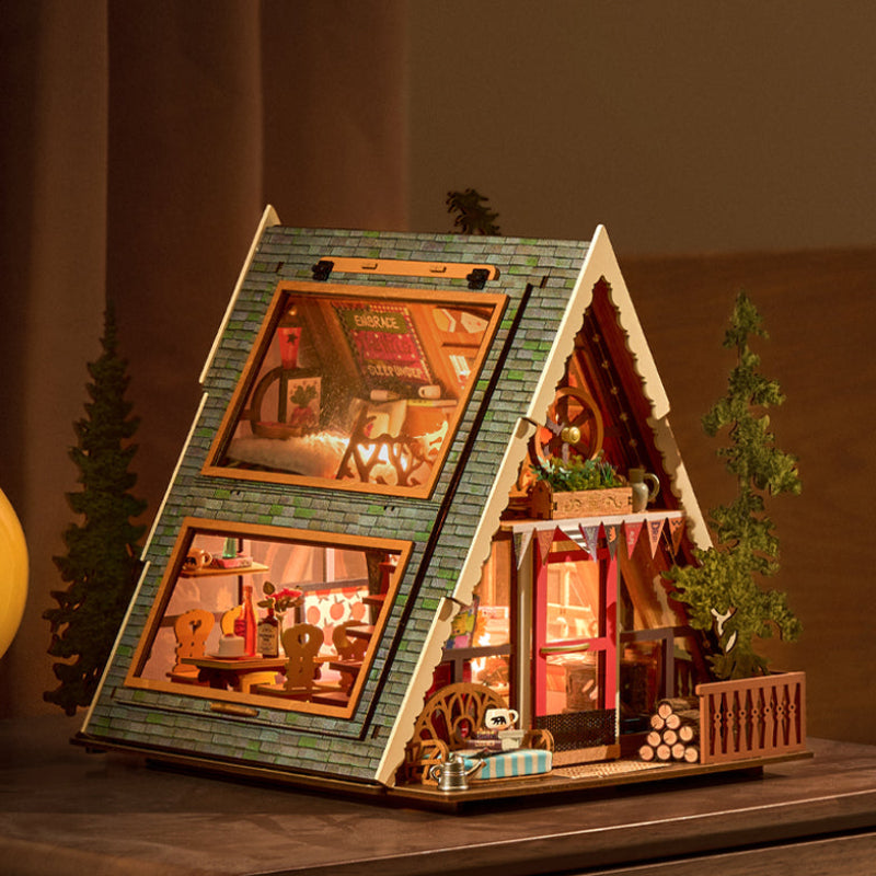 Wooden model of a cabin with interior lights on a wooden surface