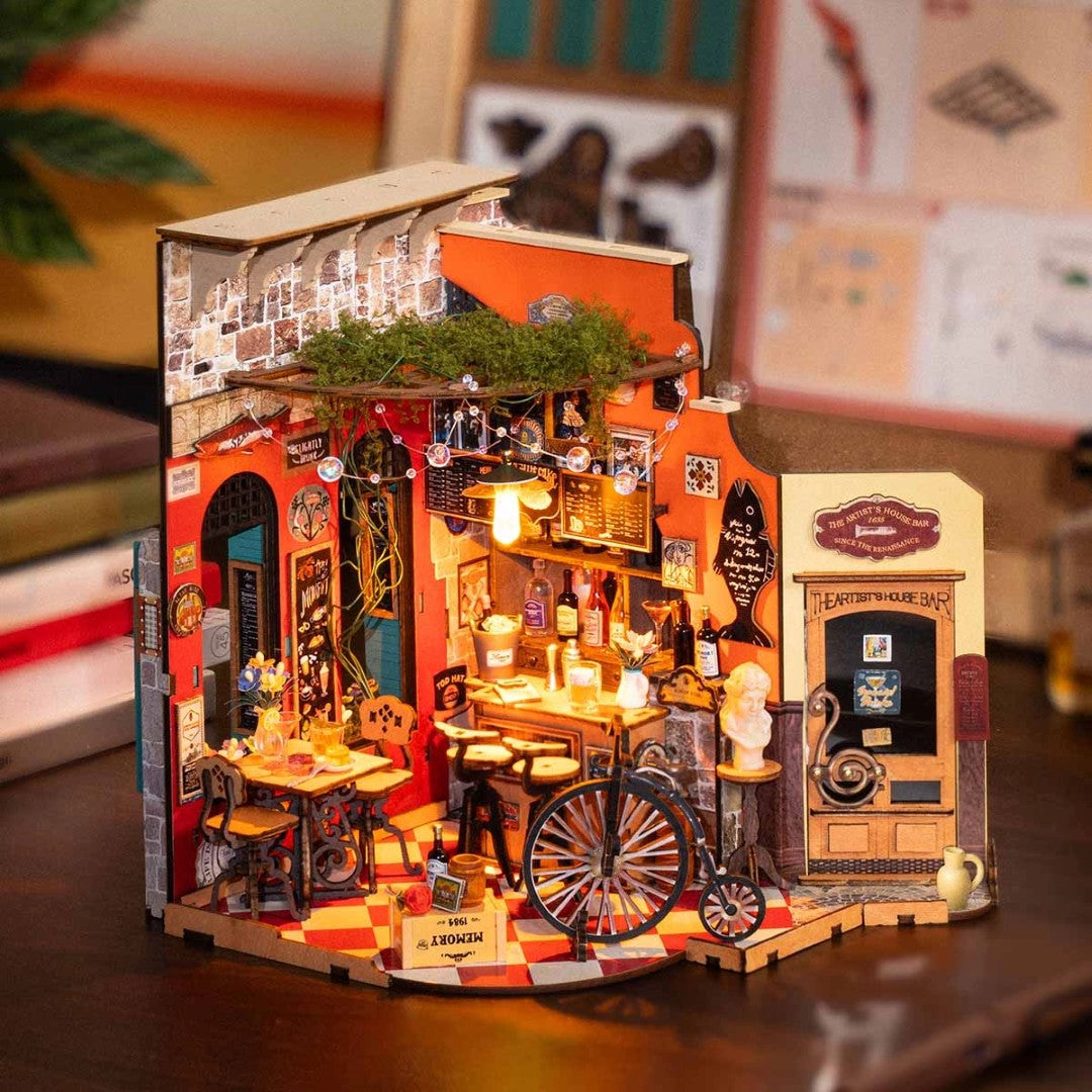 Detailed model of a vintage bar with various elements on a wooden surface.