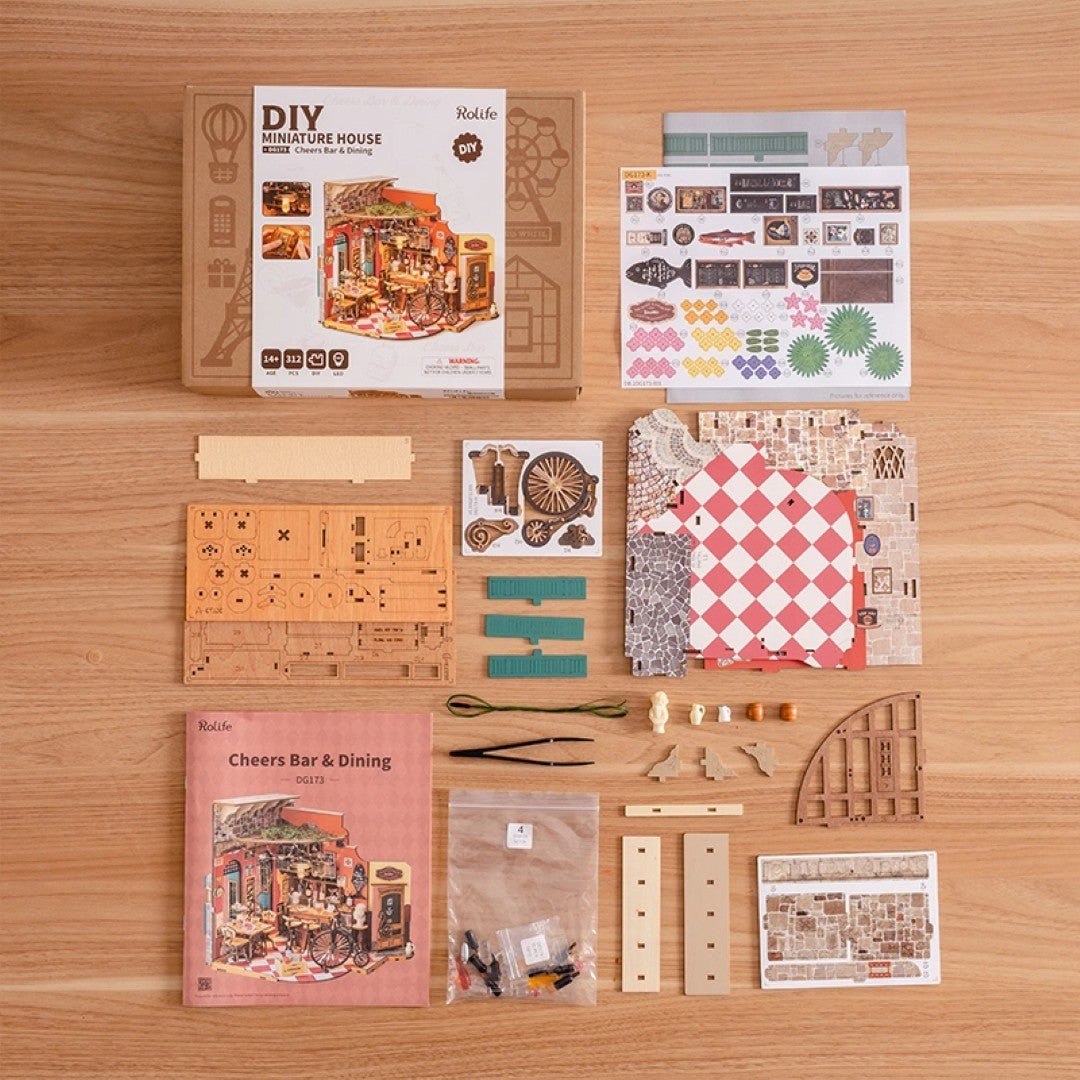 Collection of miniature house building kit components on a wooden surface