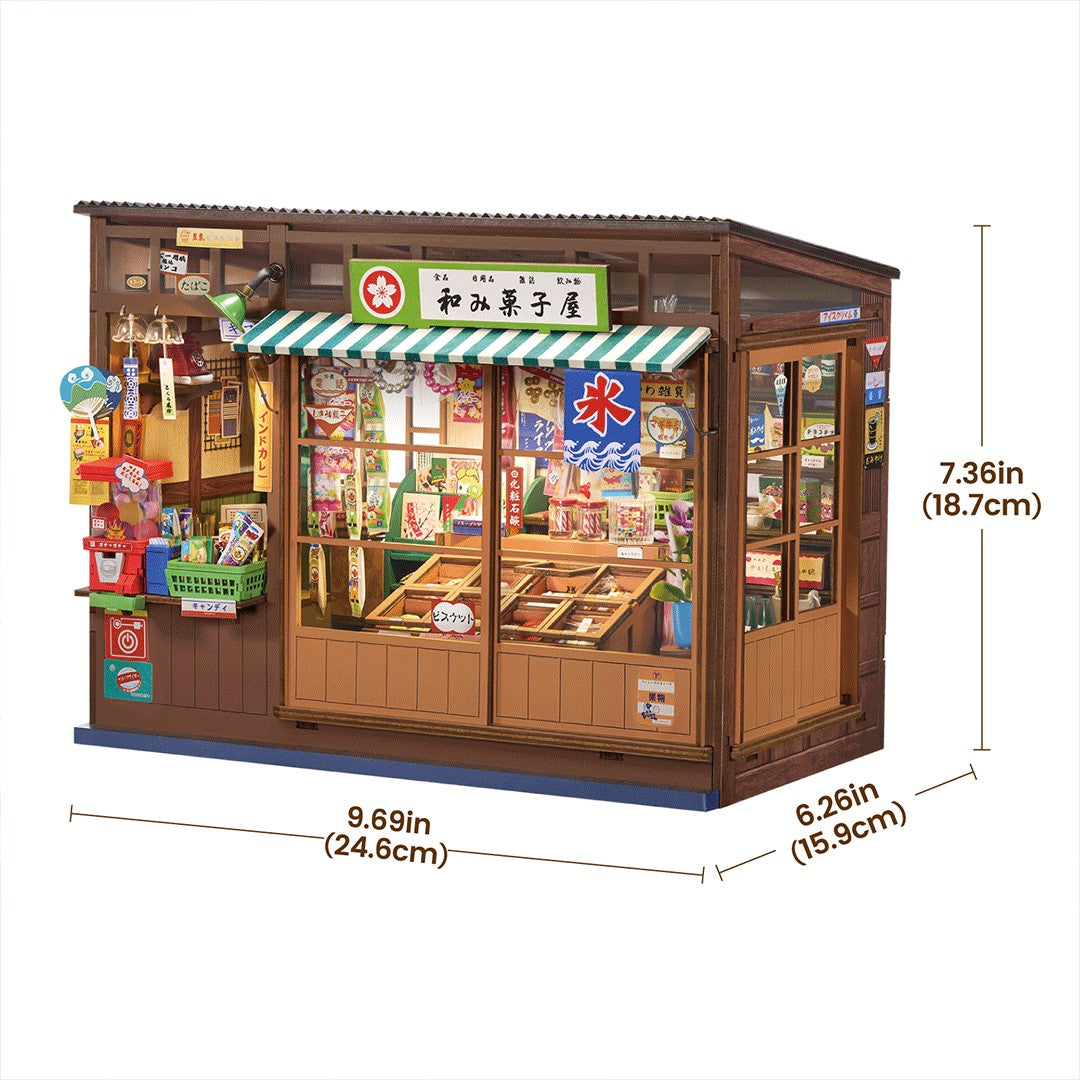 A miniature toy grocery store model with detailed windows, shelves, and a green-and-white striped awning, shown with dimension lines and measurements on a white background.