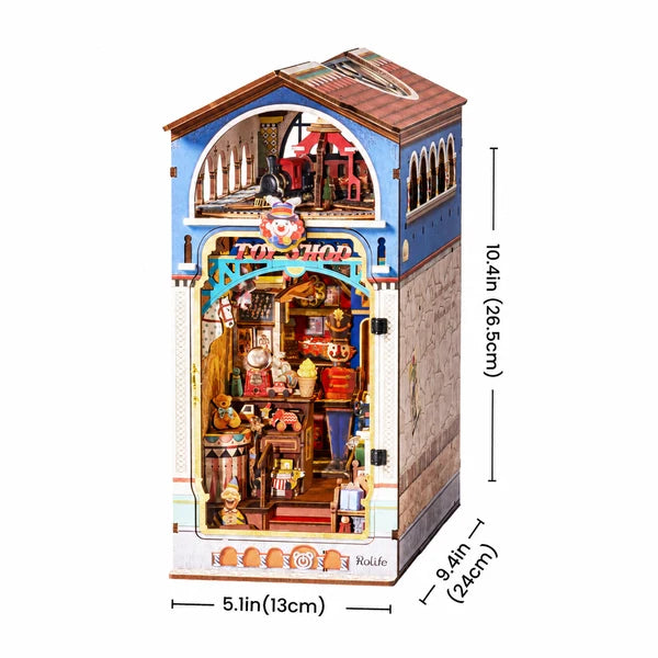 A miniature dollhouse-style shop building with detailed interior scenes, shown on a white background with dimension labels indicating 10.4 in height, 5.