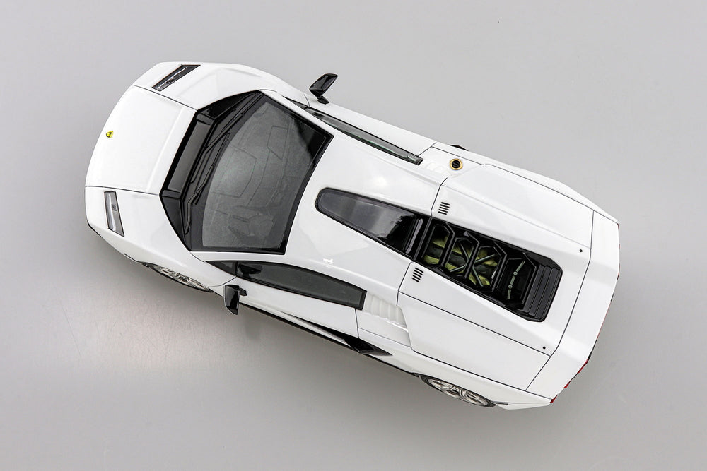 Top-down view of a white lamborghini countach model car on a gray background