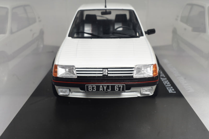 Peugeot 205 GTI 1.9 1985 1:24 scale diecast model on stand with display case front