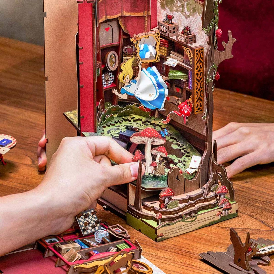 Detailed miniature diorama with a person interacting with it on a wooden surface