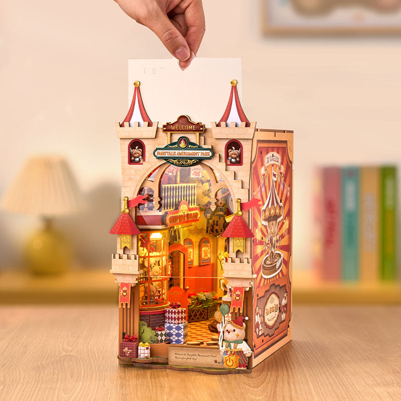 Wooden castle model with lights and details, held by a hand on a wooden surface.